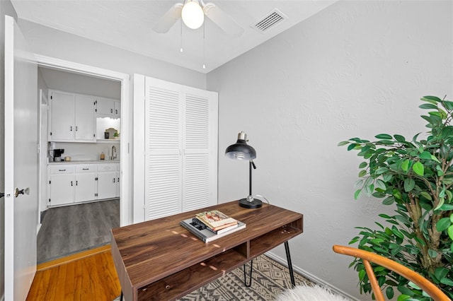 office featuring hardwood / wood-style flooring, ceiling fan, and sink