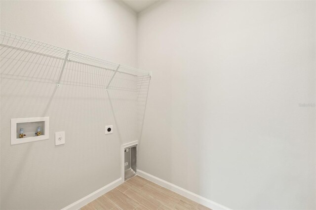 clothes washing area featuring washer hookup, light hardwood / wood-style floors, and electric dryer hookup