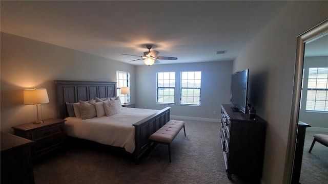 bedroom featuring dark carpet, multiple windows, and ceiling fan