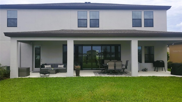 rear view of house featuring outdoor lounge area, a patio area, and a yard