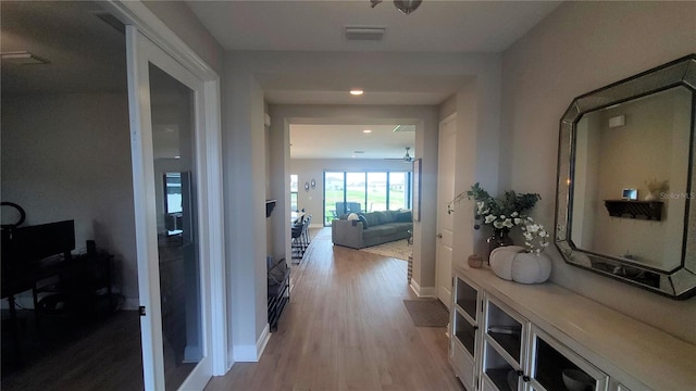 corridor with light hardwood / wood-style floors