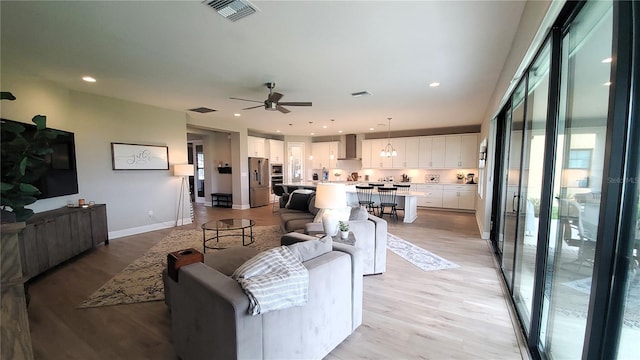 living room featuring ceiling fan and light hardwood / wood-style floors