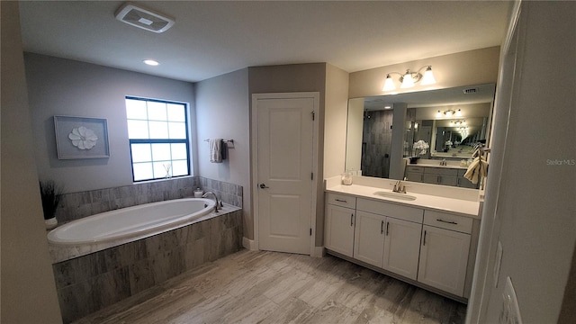 bathroom with vanity, separate shower and tub, and wood-type flooring