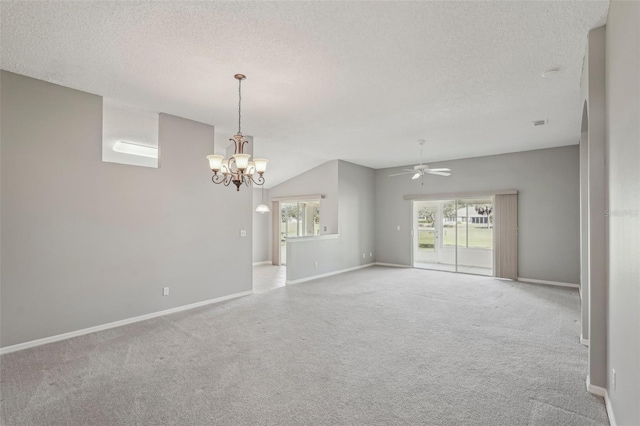 carpeted spare room featuring ceiling fan with notable chandelier and a textured ceiling