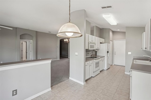 kitchen with white appliances, sink, light tile patterned floors, decorative light fixtures, and white cabinetry