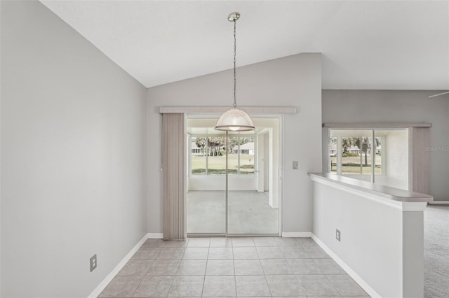 unfurnished dining area with light tile patterned flooring and vaulted ceiling