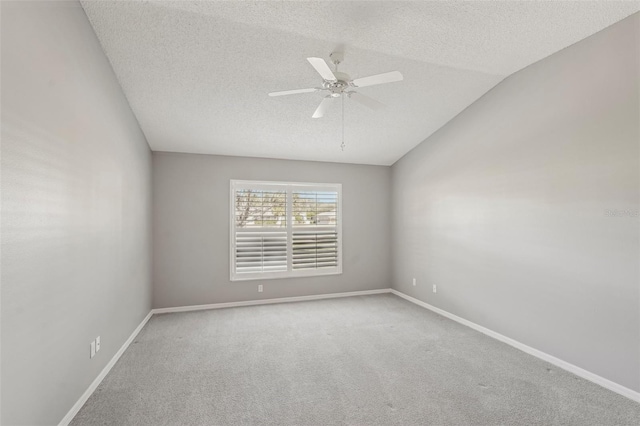 unfurnished room featuring vaulted ceiling, ceiling fan, carpet flooring, and a textured ceiling