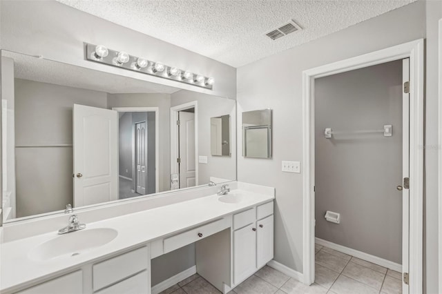 bathroom with vanity, a textured ceiling, and tile patterned floors