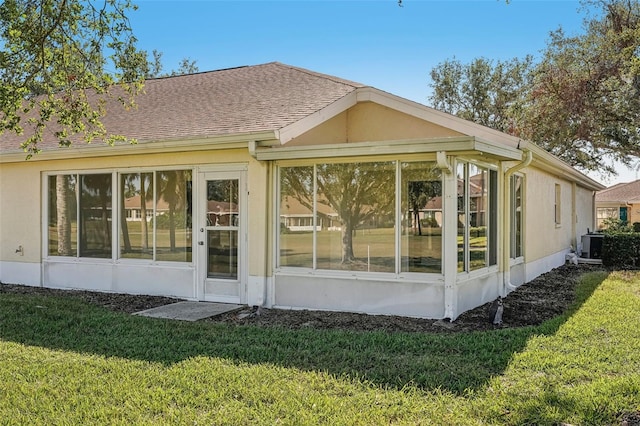 back of property with a lawn, a sunroom, and cooling unit