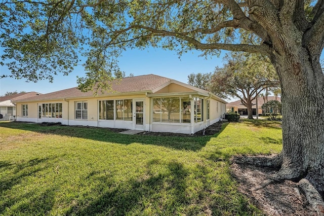 back of property featuring a yard and a sunroom