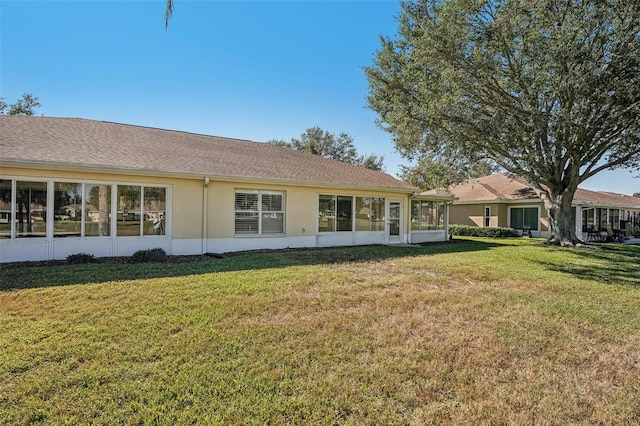 back of house with a sunroom and a yard