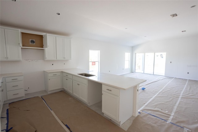 3430 Sarto Ln, Rotonda West, FL 33947 - kitchen with a peninsula, vaulted ceiling, open floor plan, and white cabinetry