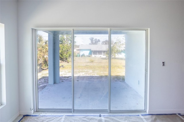 doorway featuring baseboards