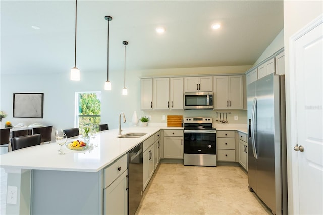 kitchen with decorative light fixtures, a peninsula, stainless steel appliances, light countertops, and a sink