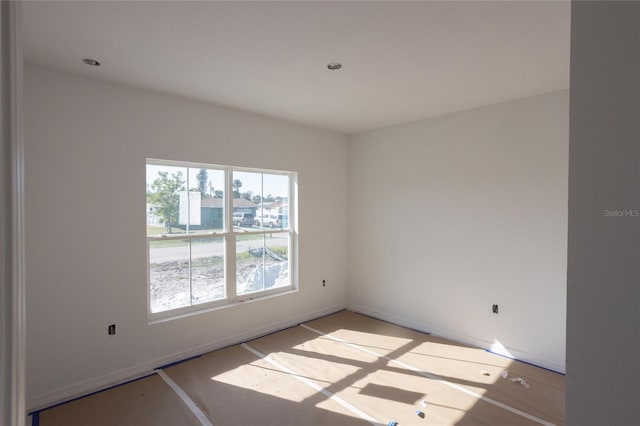 unfurnished room with baseboards