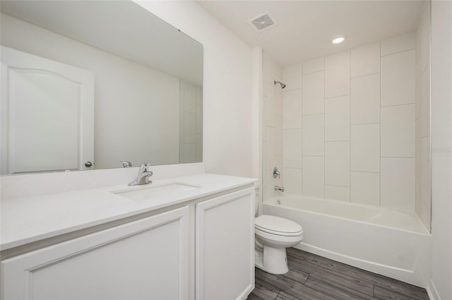 full bathroom featuring tiled shower / bath combo, toilet, wood-type flooring, and vanity