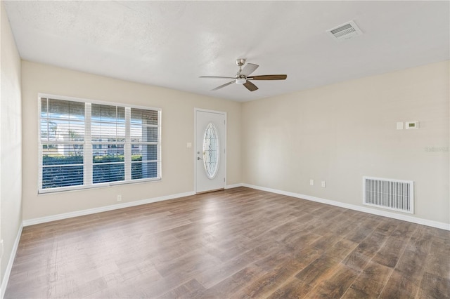 spare room with ceiling fan, wood-type flooring, and a textured ceiling