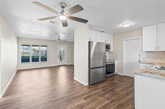 9201 40th Way N, Pinellas Park, FL 33782 - kitchen with stainless steel appliances, dark wood-style flooring, light stone counters, white cabinets, and decorative backsplash