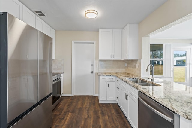 9201 40th Way N, Pinellas Park, FL 33782 - kitchen featuring appliances with stainless steel finishes, dark wood-type flooring, backsplash, light stone countertops, and white cabinets