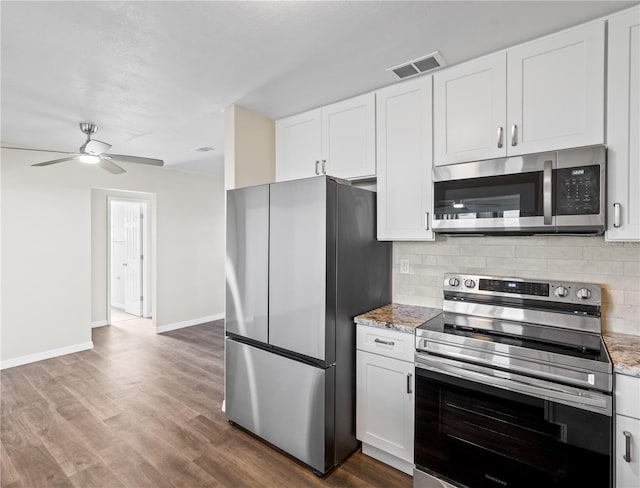 kitchen featuring white cabinetry, stainless steel appliances, tasteful backsplash, light stone counters, and dark hardwood / wood-style floors