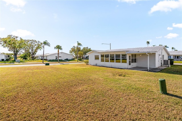 exterior space with a lawn and central air condition unit