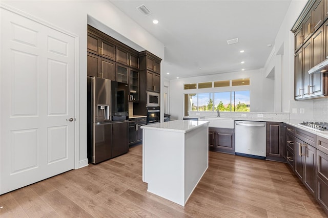 kitchen featuring a center island, light wood-type flooring, sink, and appliances with stainless steel finishes