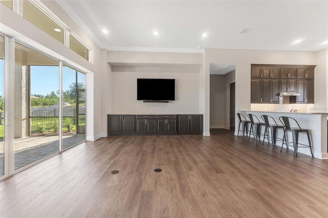 unfurnished living room featuring dark hardwood / wood-style flooring and ornamental molding