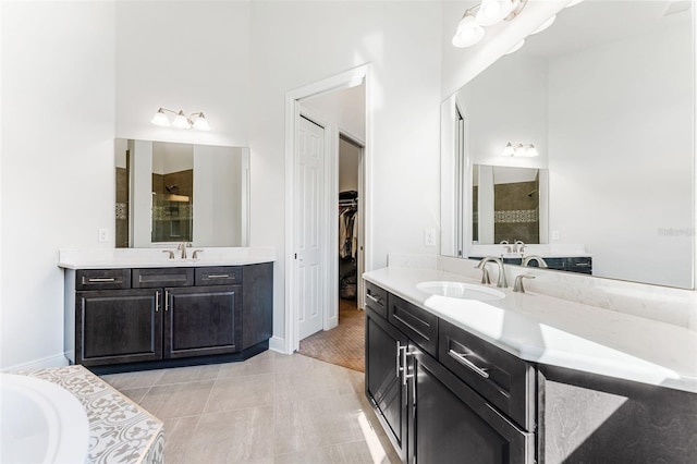 bathroom with a shower, tile patterned flooring, and vanity