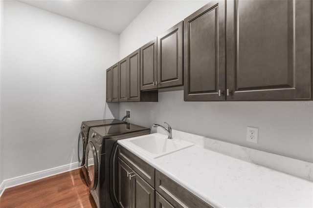 laundry area with dark hardwood / wood-style flooring, cabinets, sink, and washing machine and clothes dryer