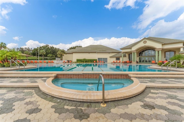 view of pool featuring a hot tub and a patio area