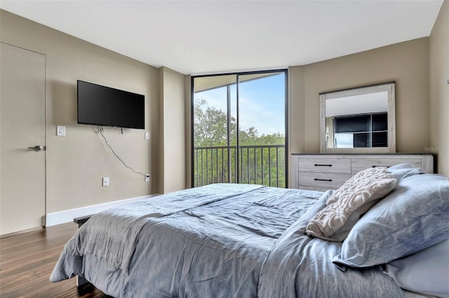 bedroom with access to outside and dark hardwood / wood-style floors