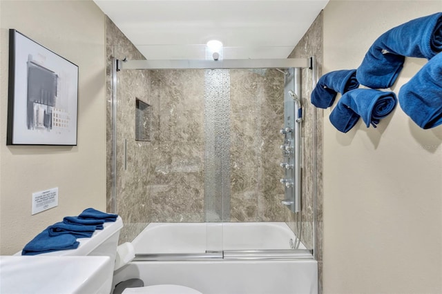 bathroom with combined bath / shower with glass door and toilet