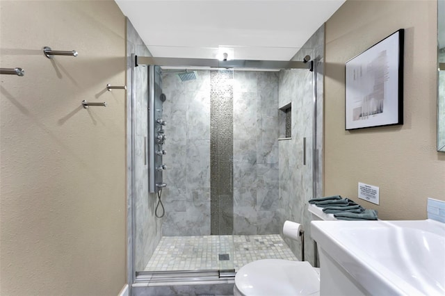 bathroom with a shower with door and toilet