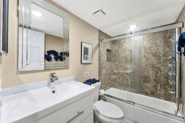 full bathroom featuring vanity, toilet, and bath / shower combo with glass door