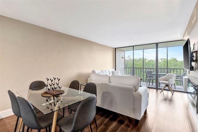 dining area featuring dark hardwood / wood-style floors and a wall of windows