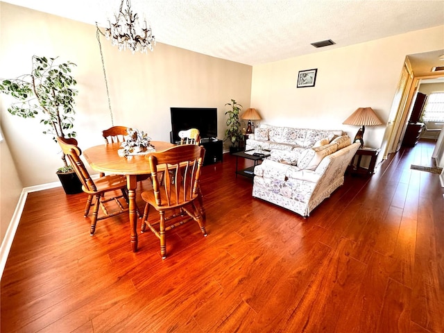 1235 S Highland Ave Unit 2-308, Clearwater, FL 33756 - dining room with dark wood finished floors, a textured ceiling, baseboards, and a chandelier