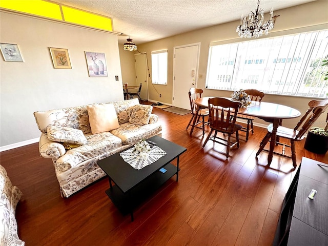 living room featuring a textured ceiling, a chandelier, and dark hardwood / wood-style floors