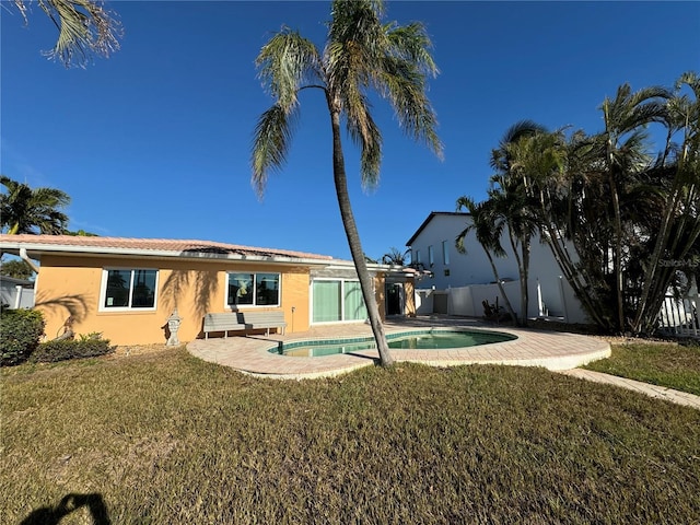 back of house with a lawn and a patio area