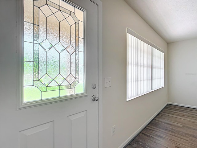 doorway to outside with dark hardwood / wood-style flooring and a textured ceiling