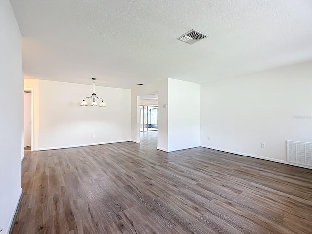 unfurnished room featuring dark hardwood / wood-style flooring and a textured ceiling