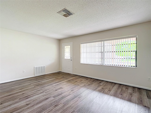 empty room featuring hardwood / wood-style floors and a textured ceiling