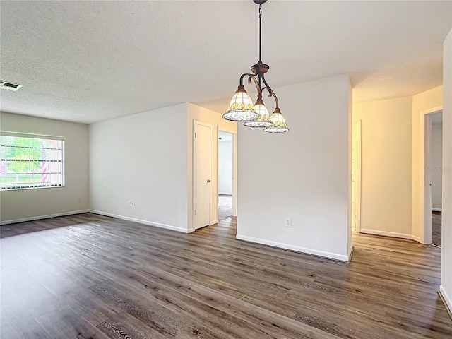 empty room with a textured ceiling and dark hardwood / wood-style floors