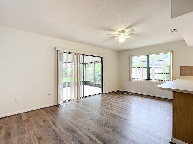 interior space featuring wood-type flooring, a textured ceiling, and ceiling fan