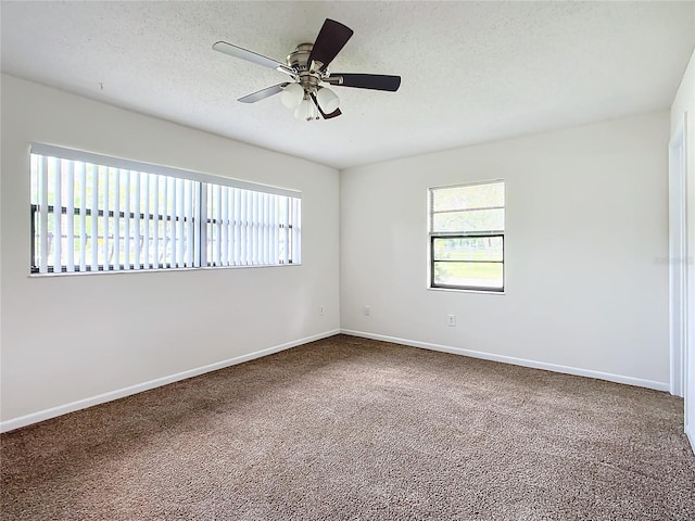 unfurnished room with carpet flooring, ceiling fan, and a textured ceiling