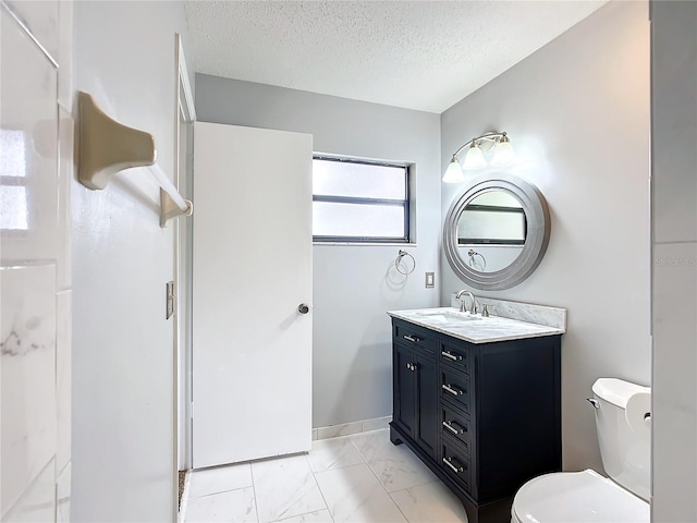 bathroom with vanity, toilet, and a textured ceiling