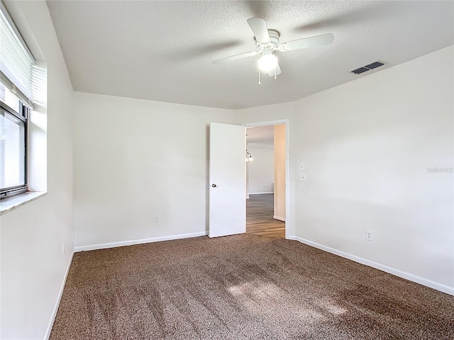 unfurnished room with ceiling fan, carpet floors, and a textured ceiling