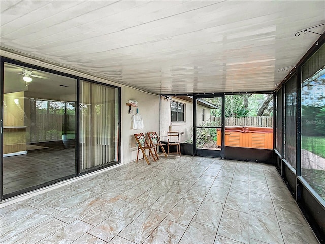 unfurnished sunroom featuring plenty of natural light, ceiling fan, and wooden ceiling