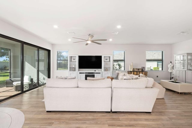 living room featuring ceiling fan, a healthy amount of sunlight, and light hardwood / wood-style floors