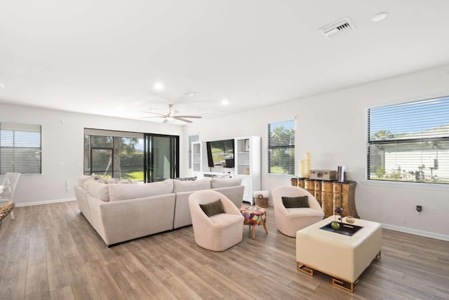 living room featuring ceiling fan and light hardwood / wood-style flooring