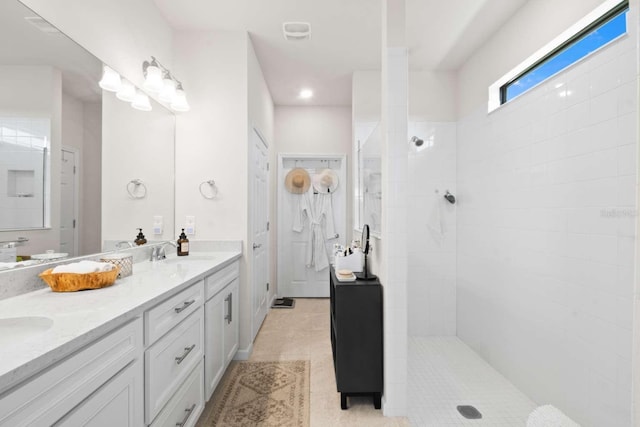 bathroom featuring tiled shower, vanity, and tile patterned floors